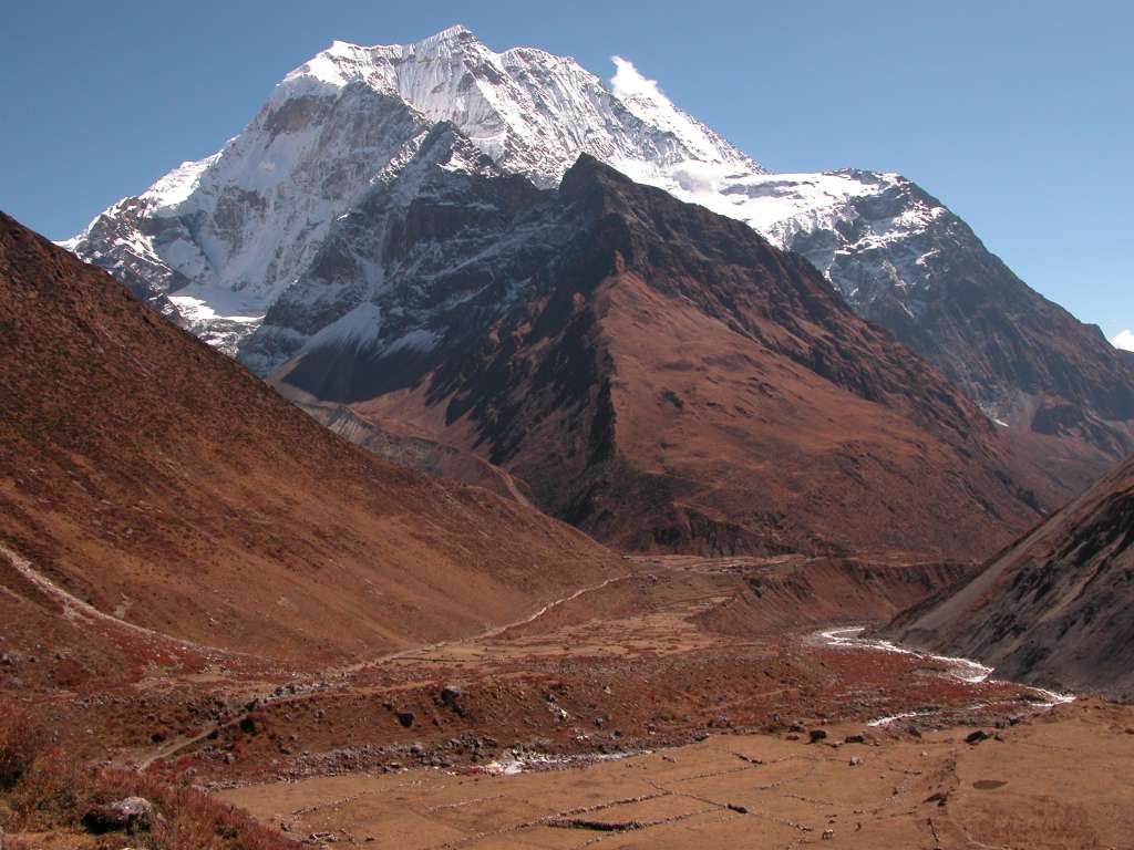 Manaslu 08 06 Samdo Benath Pang Puche I looked back to see Samdo beneath snow-topped Pang Puche (6335m). The simple houses of Samdo (3860m) stand at the junction of three valleys, with a major Tibetan trade route heading east through the village and over the Lajyang La (5098m) to Rhee village in Tibet, a days walk from here.